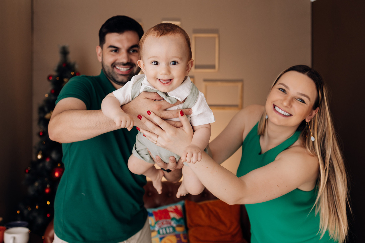 Família segurando o bebê Luca durante ensaio fotográfico de acompanhamento infantil realizado pelo Alba Estúdio em Lajeado.