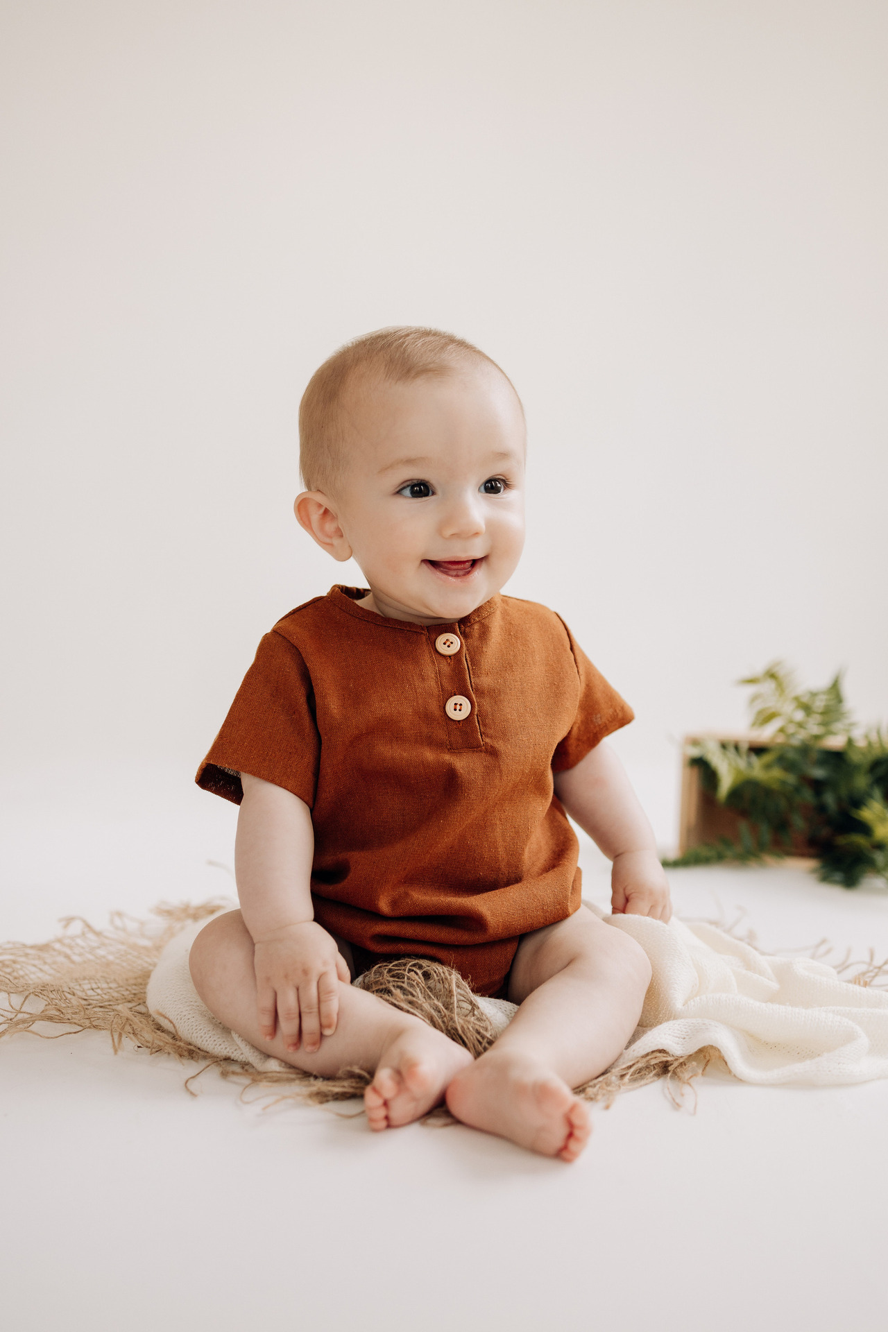 Bebê Luca sentado sorrindo durante ensaio de acompanhamento mensal infantil no Alba Estúdio em Lajeado.