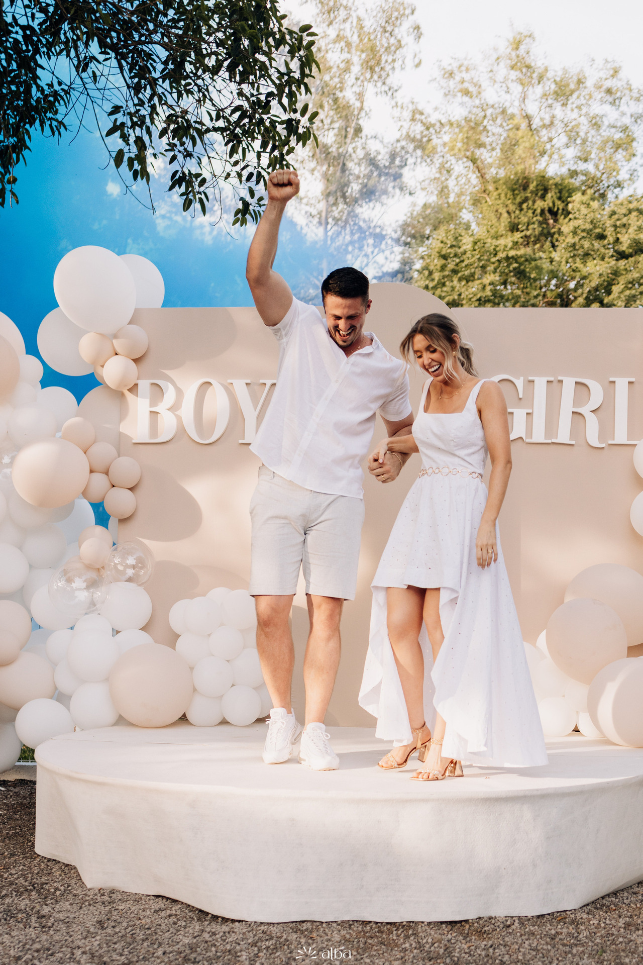 Casal comemorando durante chá revelação com fumaça azul ao fundo, registrando o momento da descoberta do bebê em evento fotografado pelo Alba Estúdio em Lajeado RS.