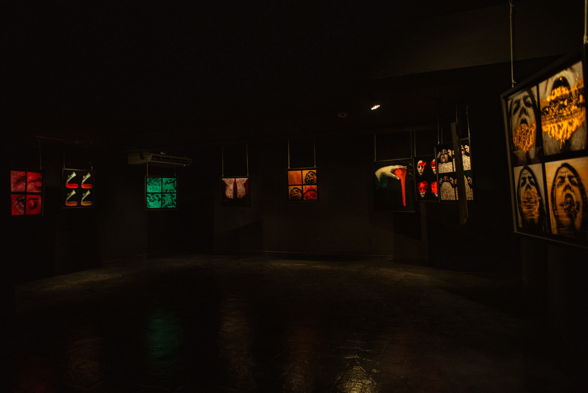 Vista geral da galeria da exposição Lírios, Rosas e Outras Flores, de Gabi Coêlho, no Sesc Centro, com múltiplas obras distribuídas em um espaço expositivo escuro e imersivo.