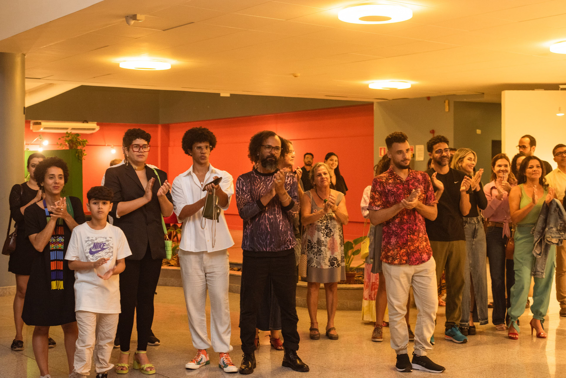 Público visitando a exposição Imensidão Íntima, de Gabi Coêlho, em Maceió, interagindo com imagens que tratam de corpo, memória e relações afetivas.