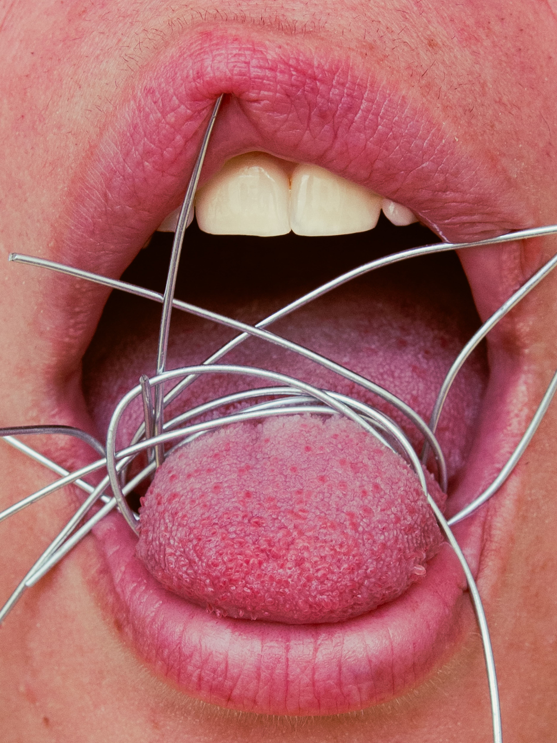 Autorretrato da artista visual Gabi Coêlho em close da boca com arames